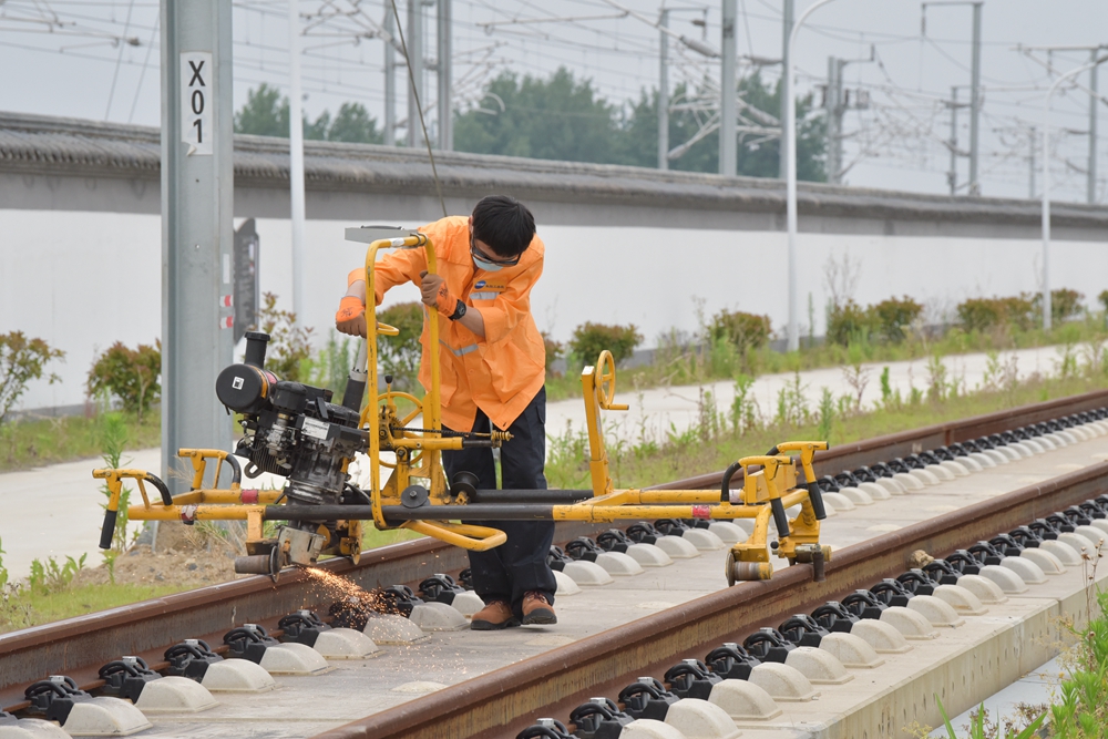 图为该段参赛选手使用廓形仪和打磨机进行精测精磨.