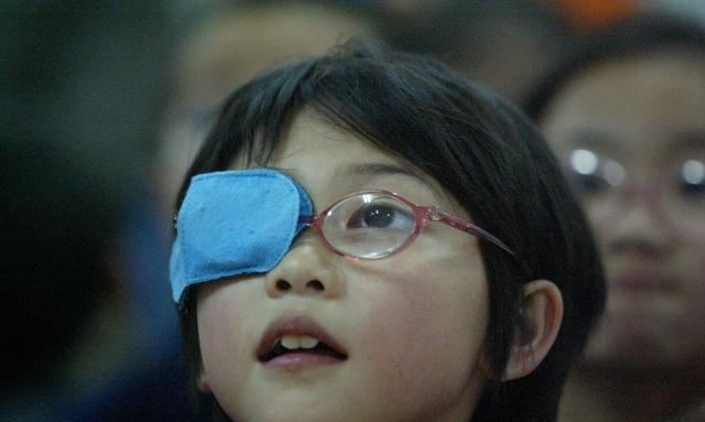 眼镜但是其中一只眼睛被用蓝布或者其它颜色的布遮盖着,这其实是弱视